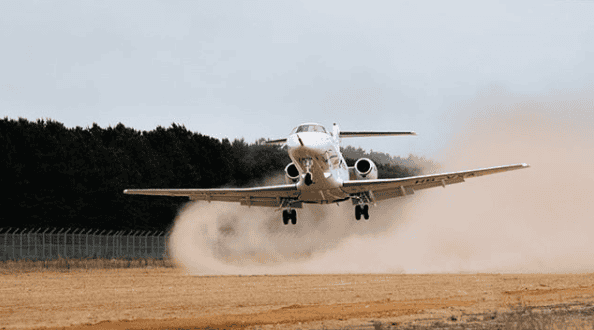 PC-24 jet landing on unpaved runway during first test flight.