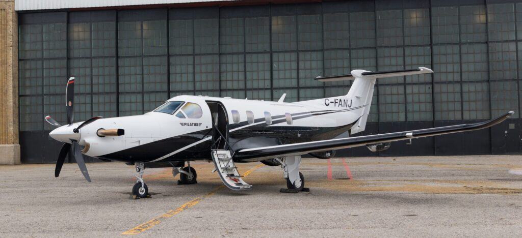 Aircraft with registration C-FANJ parked outside hangar.