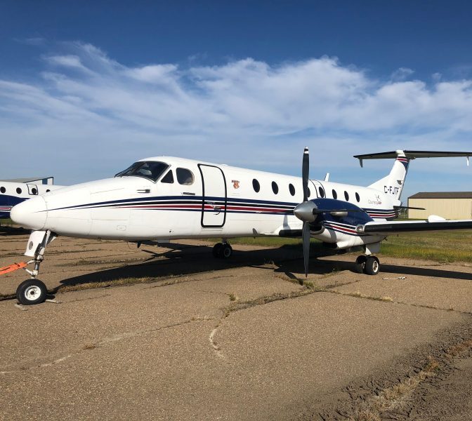 Vintage Beechcraft 1900C turboprop airplane parked outdoors.