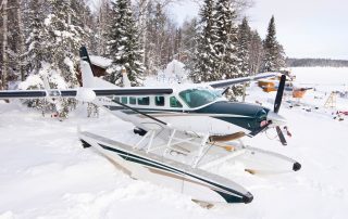 Cessna Caravan 208 aircraft parked on snowy landscape, showcasing versatile turboprop plane.