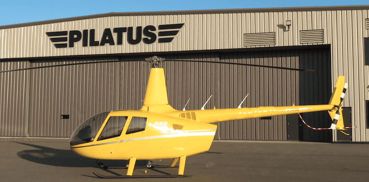 Yellow Robinson R66 helicopter parked outside Levaero facility.