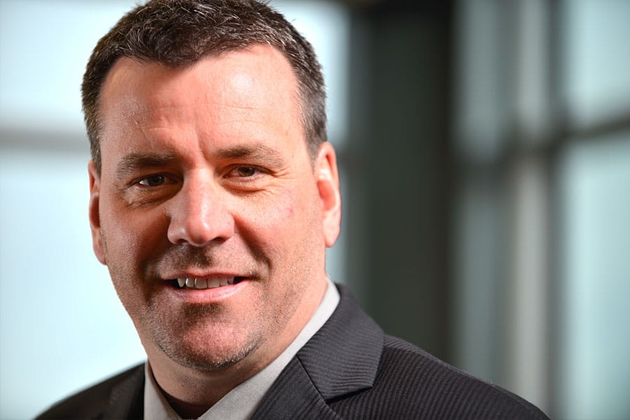 Professional businessman in formal suit smiling for the camera.