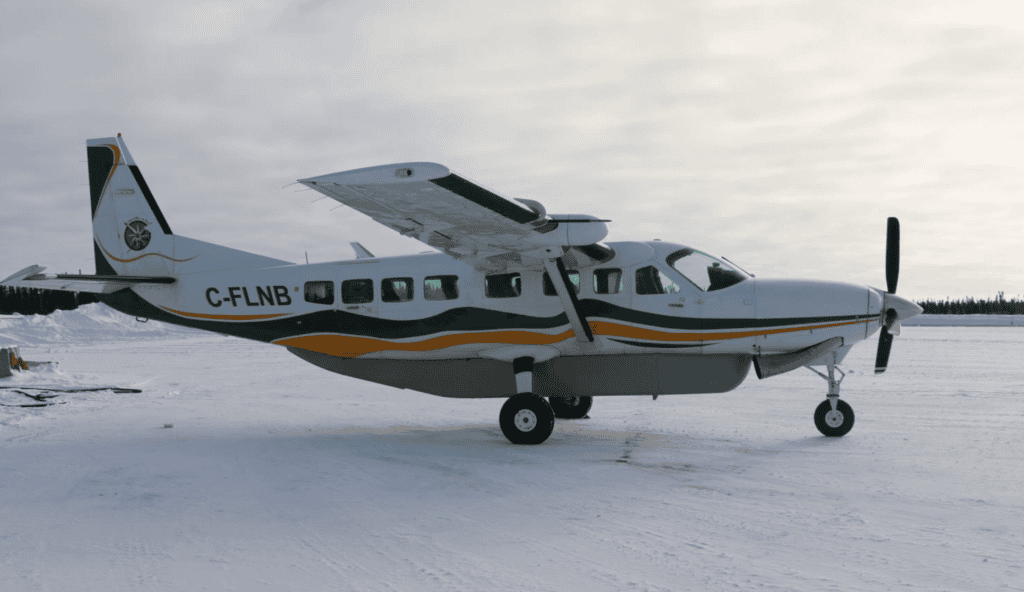 Cessna Grand Caravan 208B aircraft parked on snowy terrain, ready for flight.