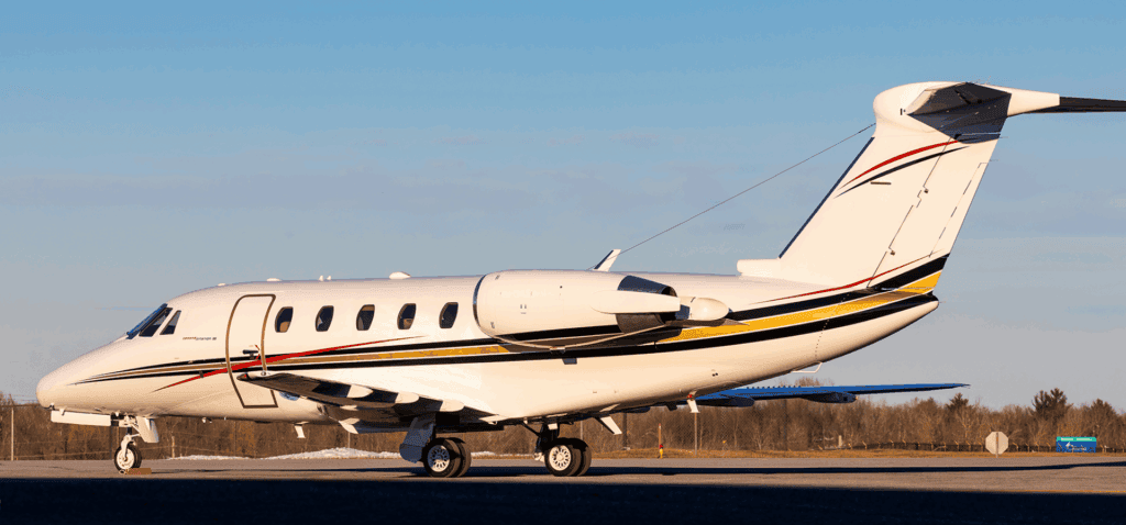 Private jet aircraft on runway with clear sky background.