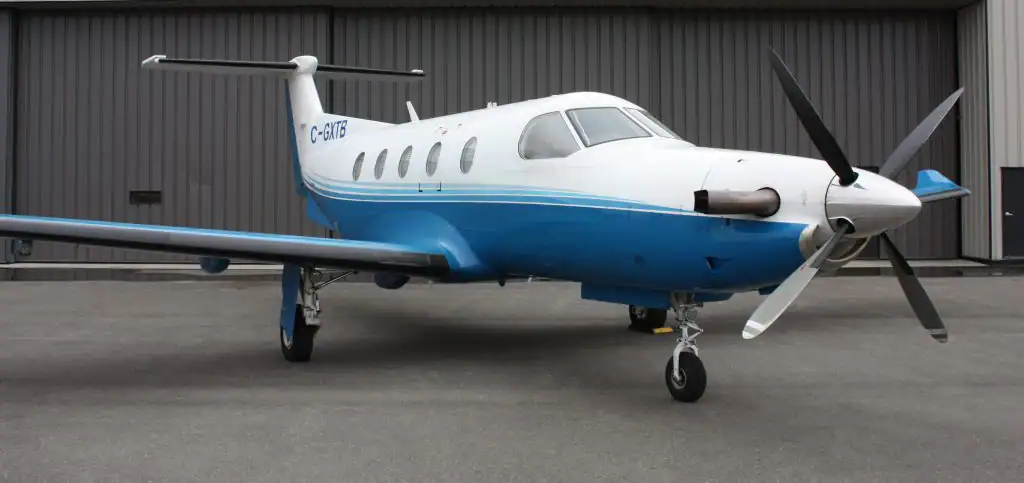 Small private propeller aircraft parked on tarmac.