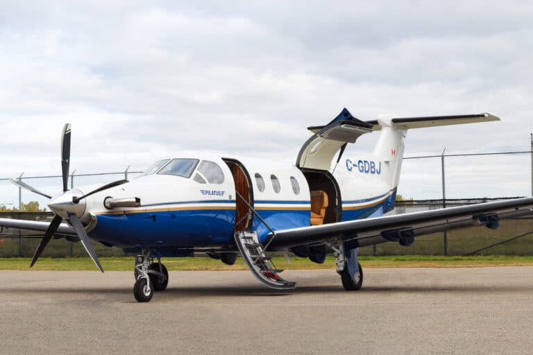 Pilatus PC-12 NG turboprop aircraft on runway with open door.