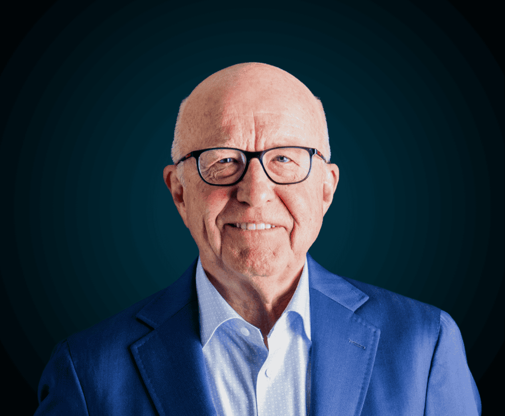 Senior professional in a blue suit smiling for the About Us page.