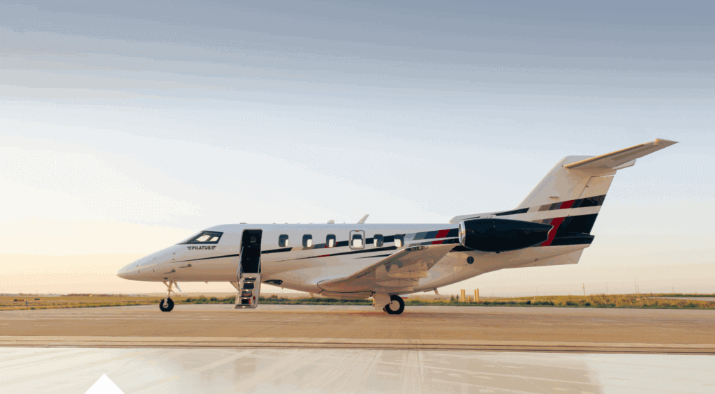 Private jet parked on runway with open door, ready for flight.