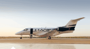 Private jet parked on runway with open door, ready for flight.