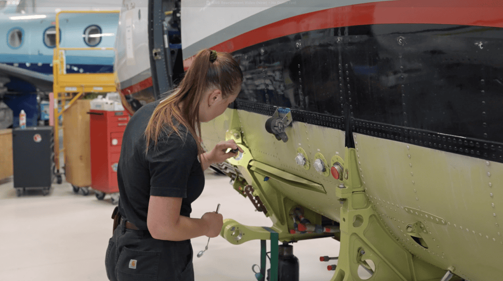 Technician inspecting aircraft fuselage during pre-purchase checkup.